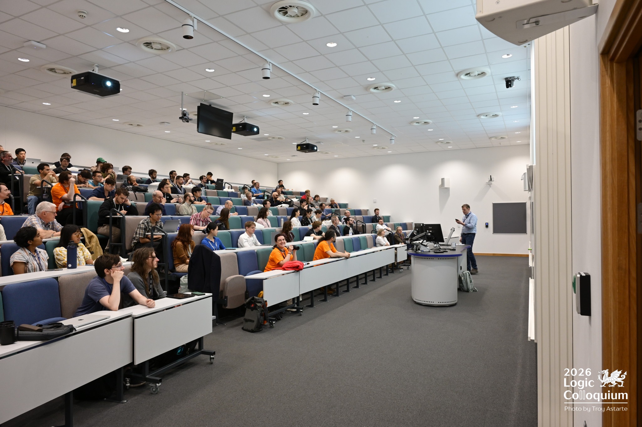 Photograph of a lecture theatre full of eager logic fans ready for the conference to start. Olga looks directly at the camera.
