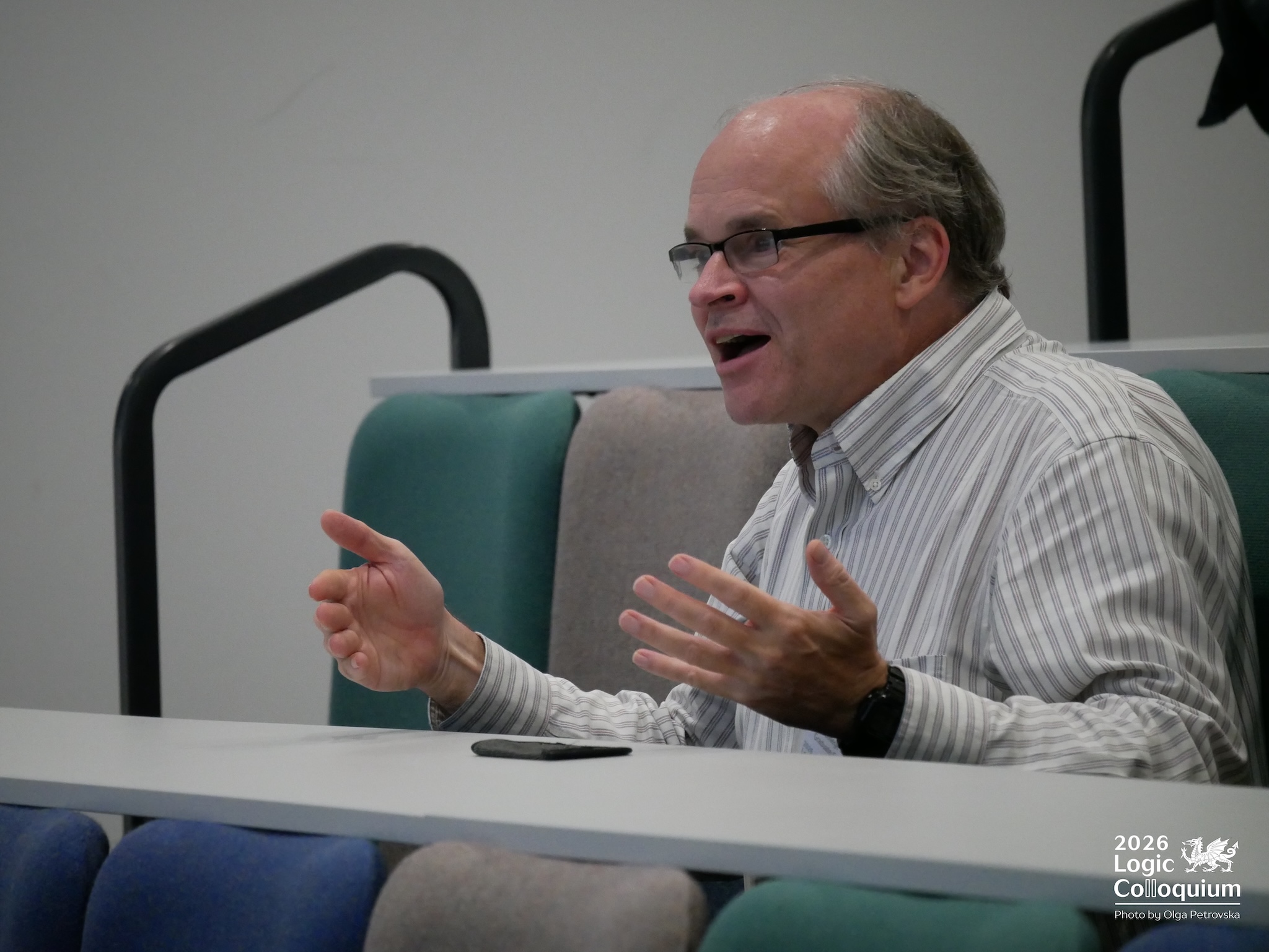 Photograph of a mathematician making a point while sitting in a lecture theatre.