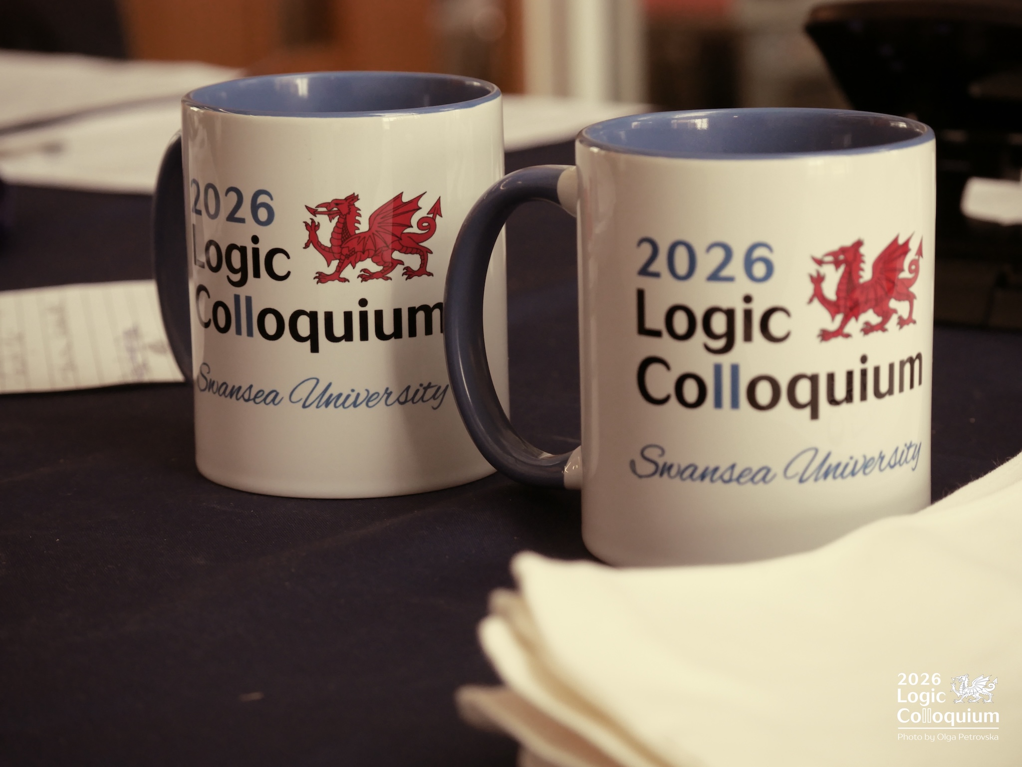 Photograph of two surprisingly nice conference mugs, white with the logo, and a blue interior and handle.