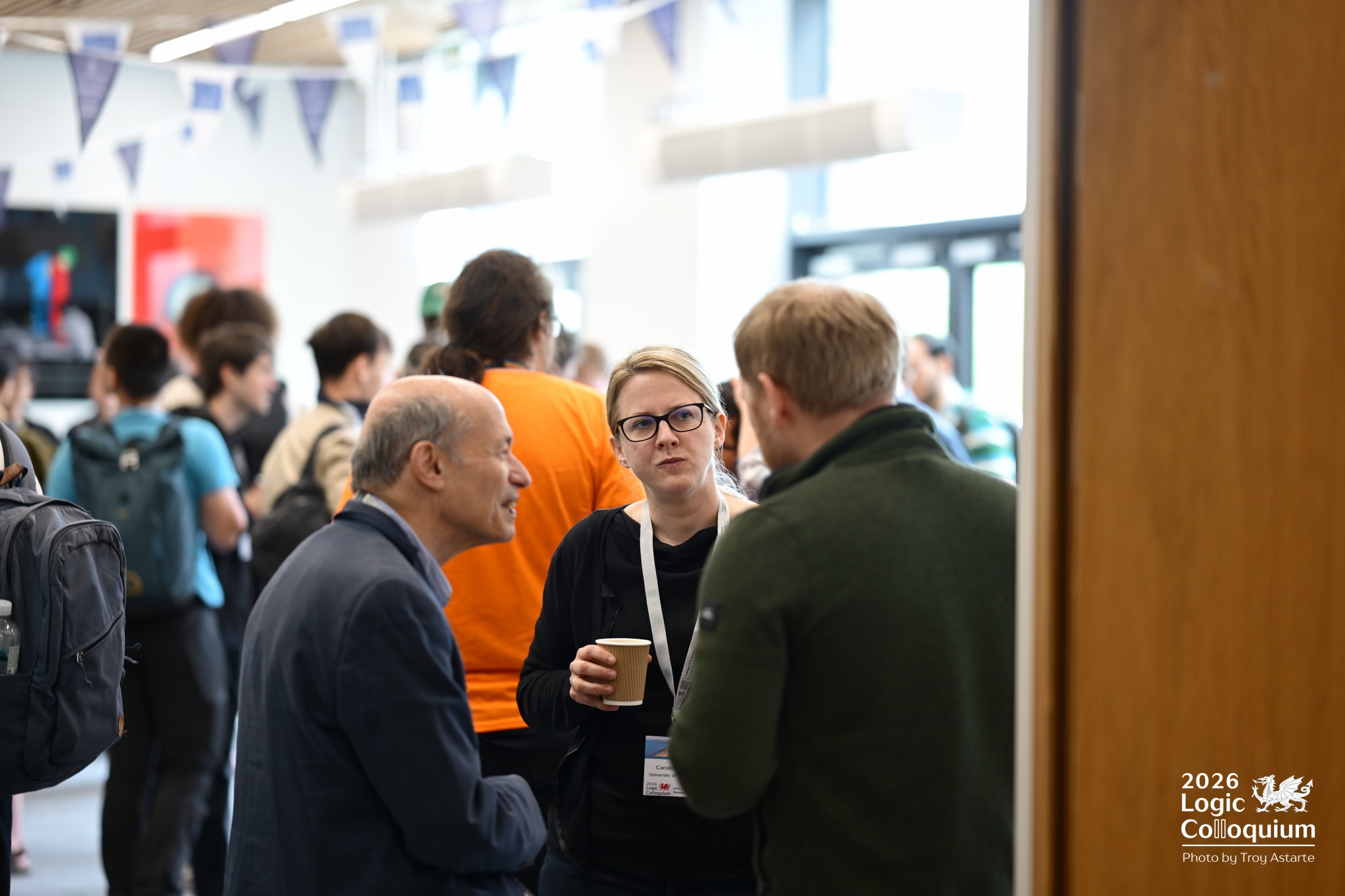 Photograph of attendees chatting in the atrium.
