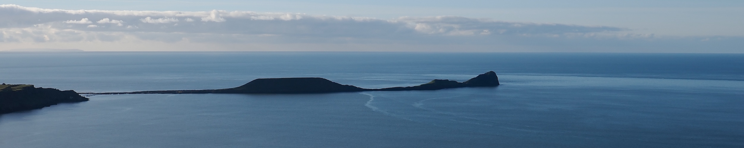 Photograph of a long peninsula stretching into the ocean, vaguely resembling a swimming dragon.